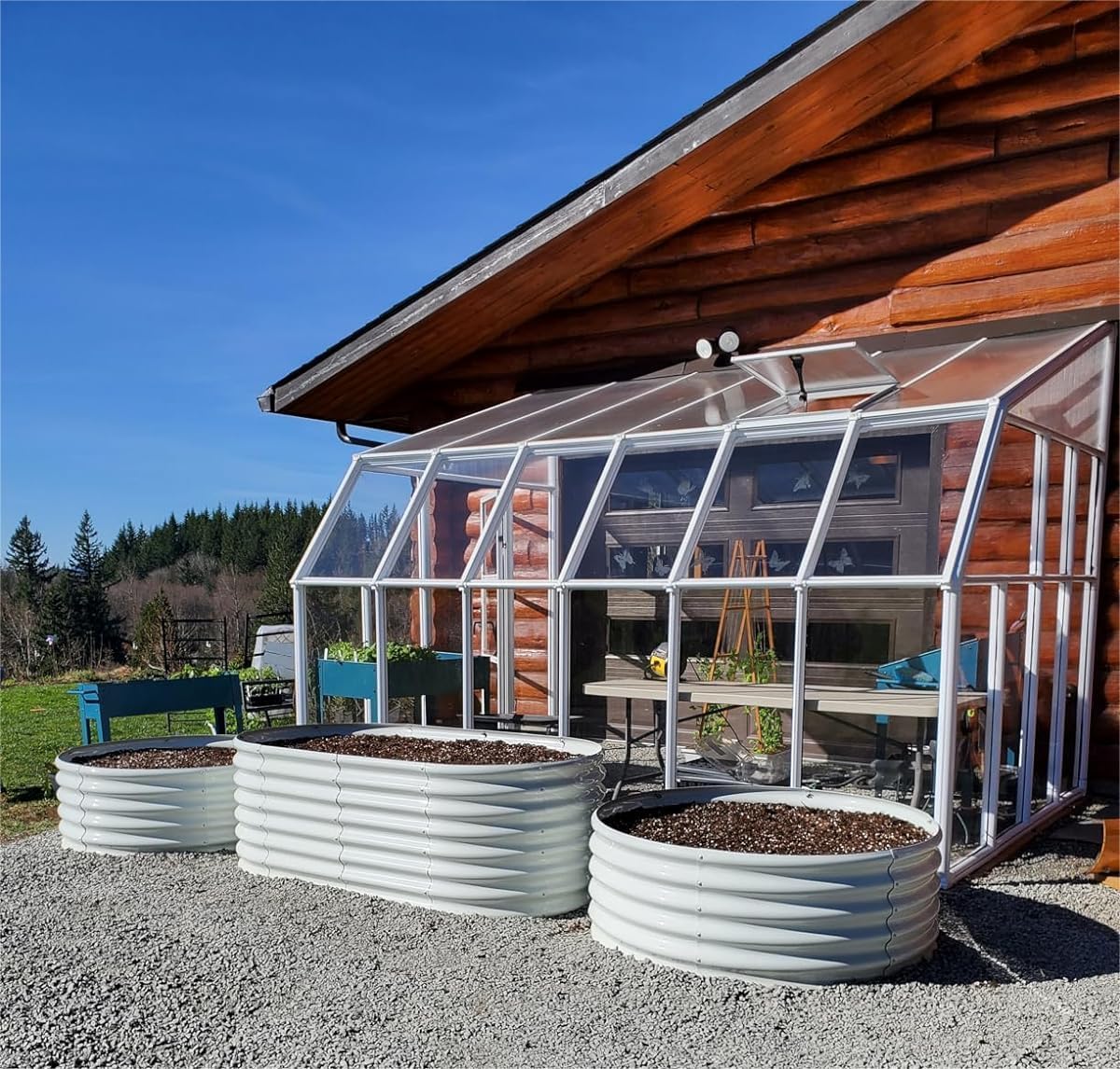 Greenhouse attached to a wooden cabin with outdoor furniture and plants. 
