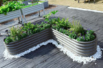 Corrugated metal garden beds with plants on a wooden deck 