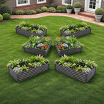 Set of raised garden beds with plants on a grassy area 