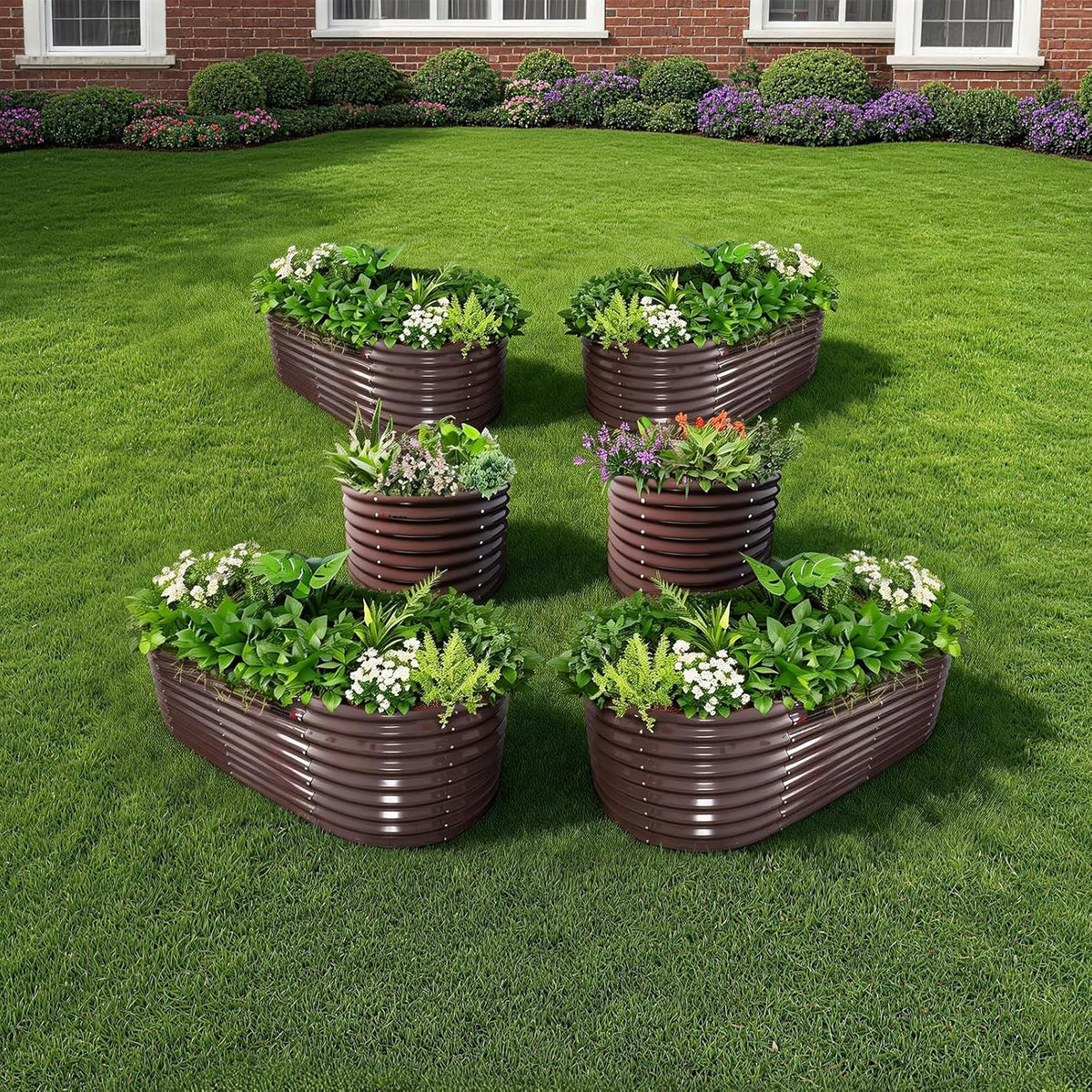 Set of five decorative planters with plants on a grassy area 