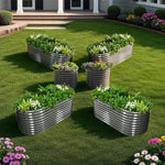 Metal garden planters with plants and flowers on a grassy lawn. 
